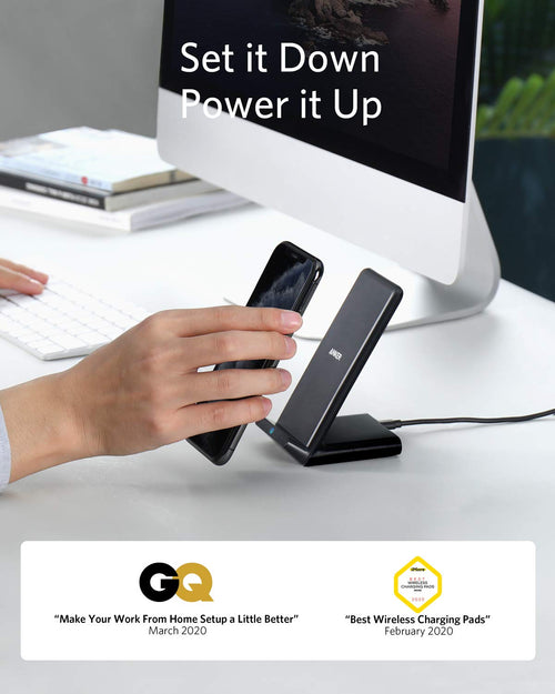 Hand placing a phone on a wireless charging pad with text 'Set it Down Power it Up' and GQ logo.