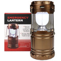 Emergency lantern in a metallic bronze/copper color with a clear glass shade and white LED light, shown next to its retail box on a white background.