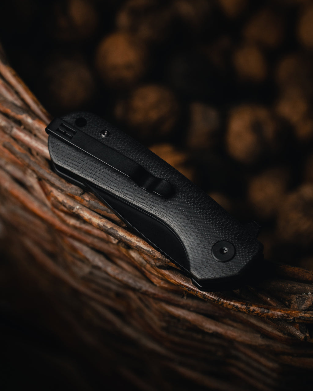 Black pocket knife on a textured brown surface