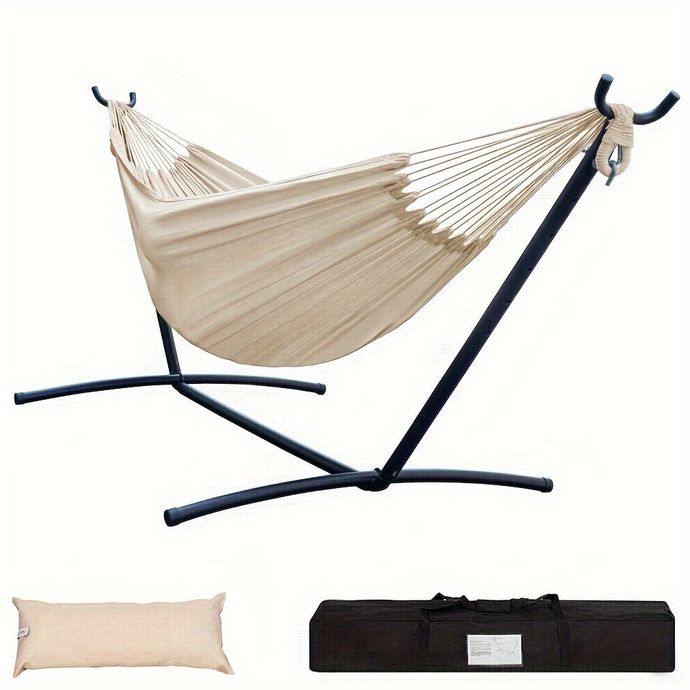 Beige hammock with black stand, pillow, and carrying bag on a white background