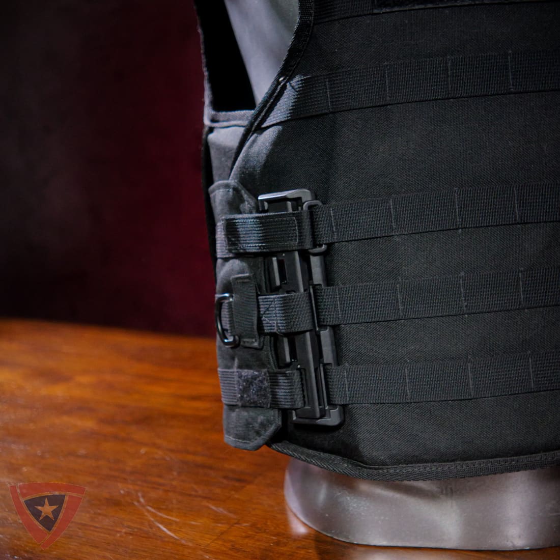 Black tactical vest on a mannequin with a wooden surface background