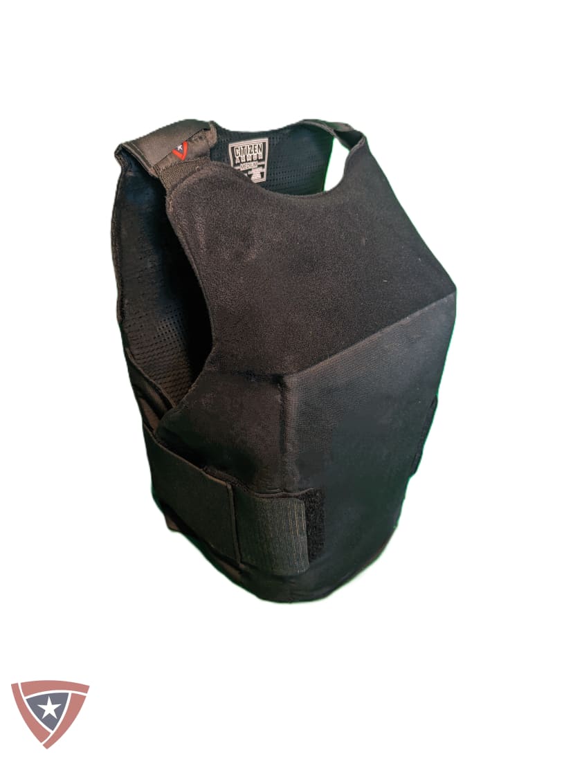 A black tactical plate carrier vest with adjustable shoulder straps and a hook-and-loop closure, shown on a plain white background.