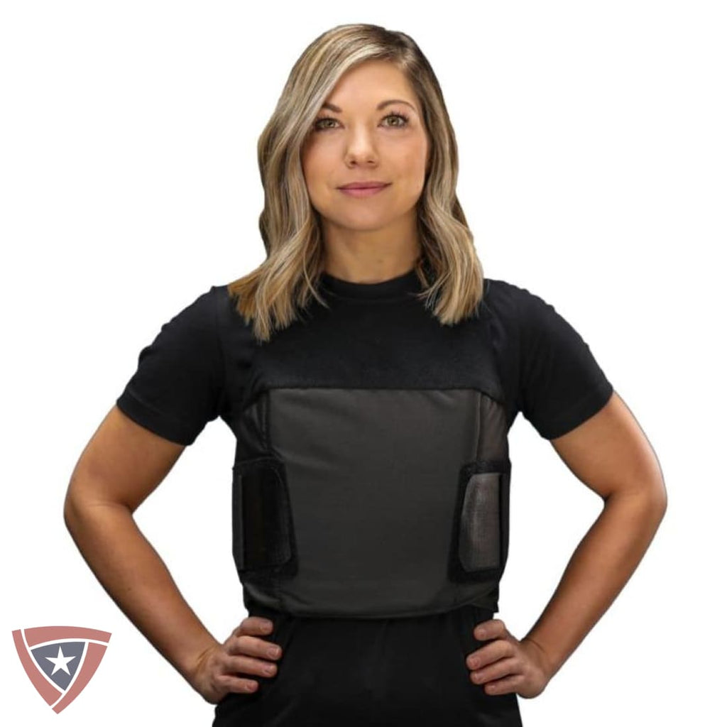 A woman modeling a black short-sleeve compression vest with a dark gray front panel and side pockets, shown against a plain white background.