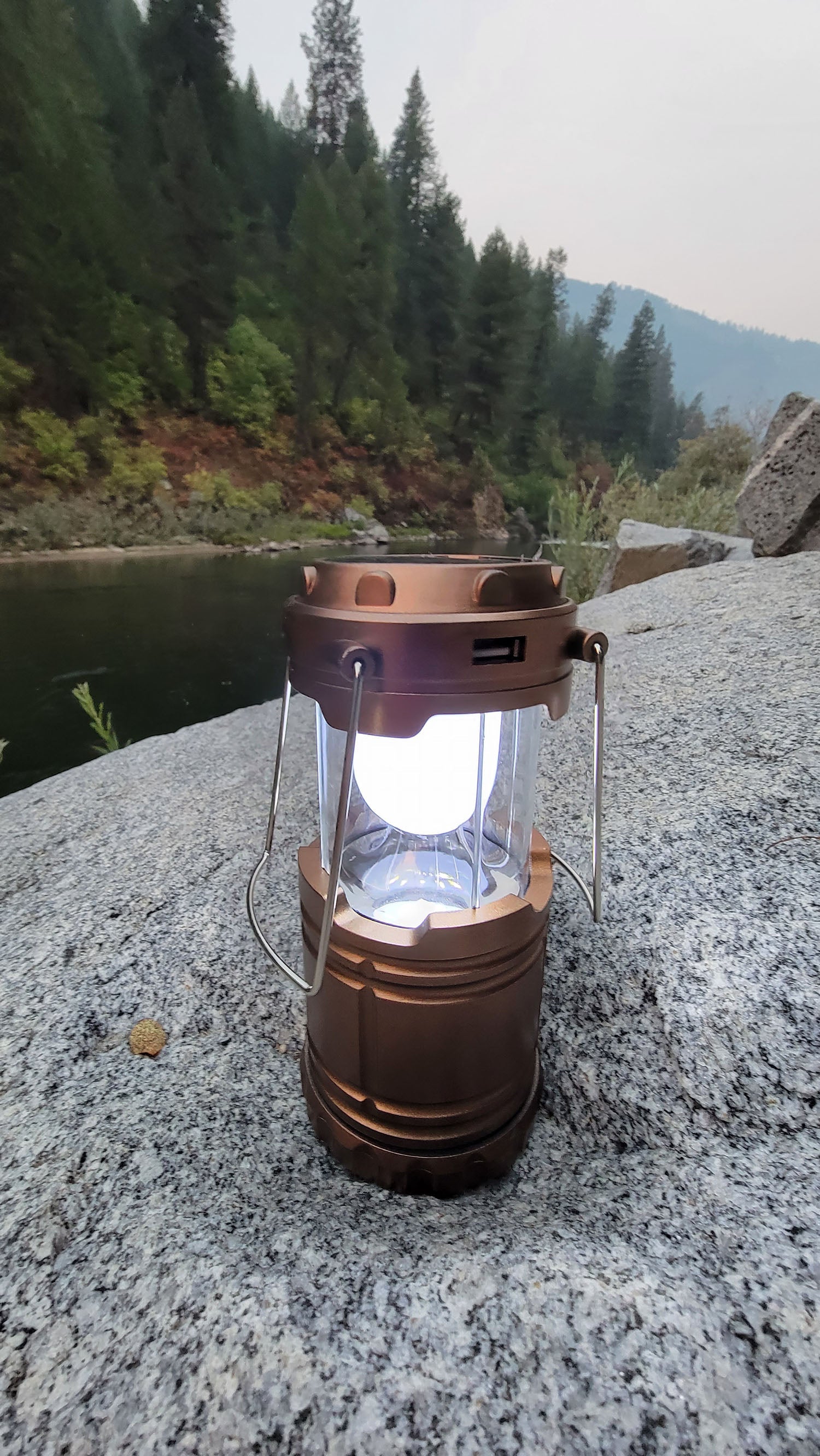Camping lantern on a rock with a forest background