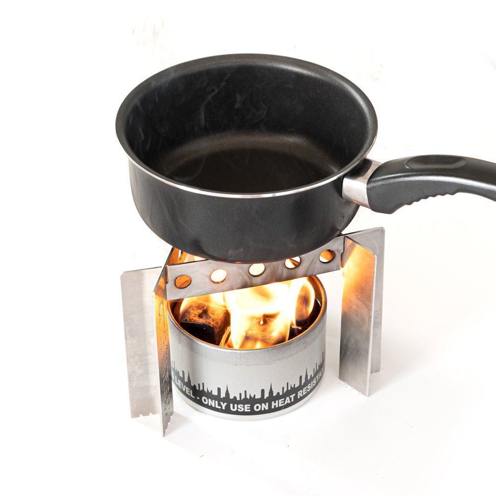 Black frying pan on a portable stove with visible flames